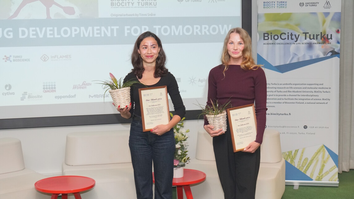 Palkitut poseeraamassa kasvin ja diplomin kanssa