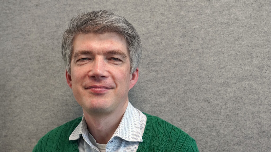 David Molnar closeup in front of a gray wall