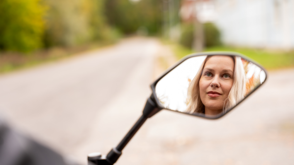 Jasmin Hannosen kasvot näkyvät moottoripyörän sivupeilistä.