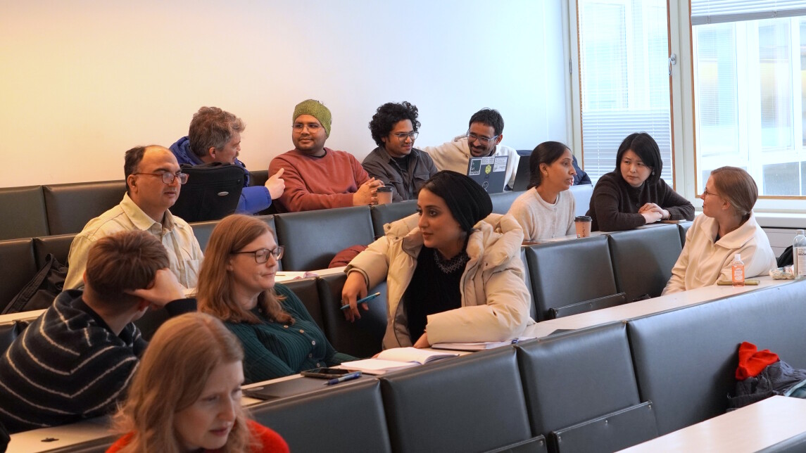 Researchers discussing in lecture hall