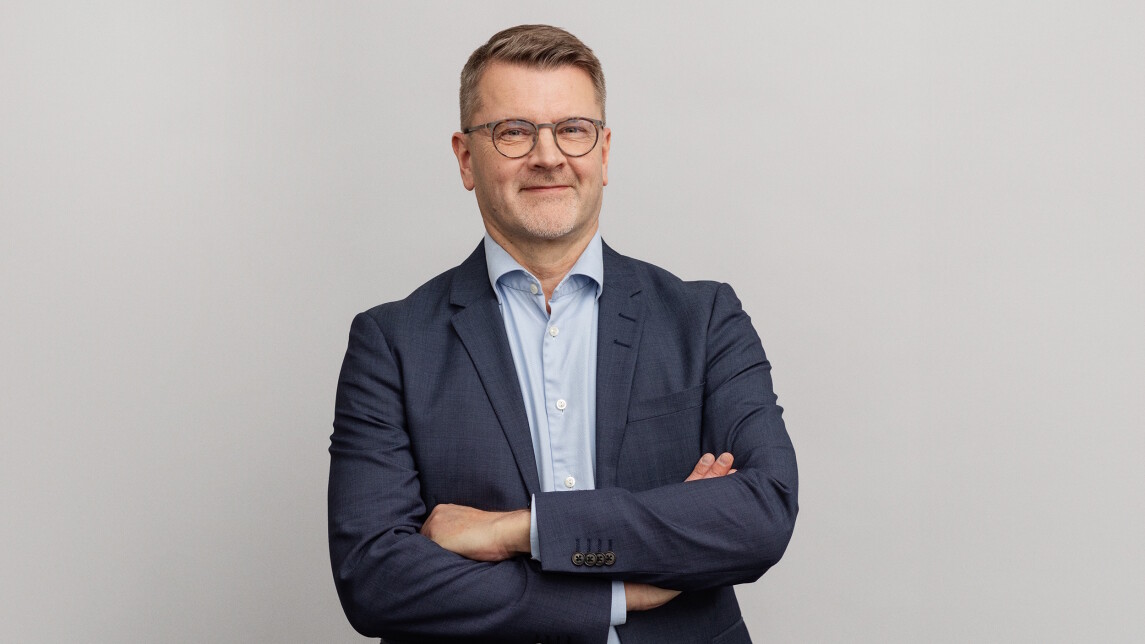 Lauri Tuomi lähikuvassa, harmaa tausta.