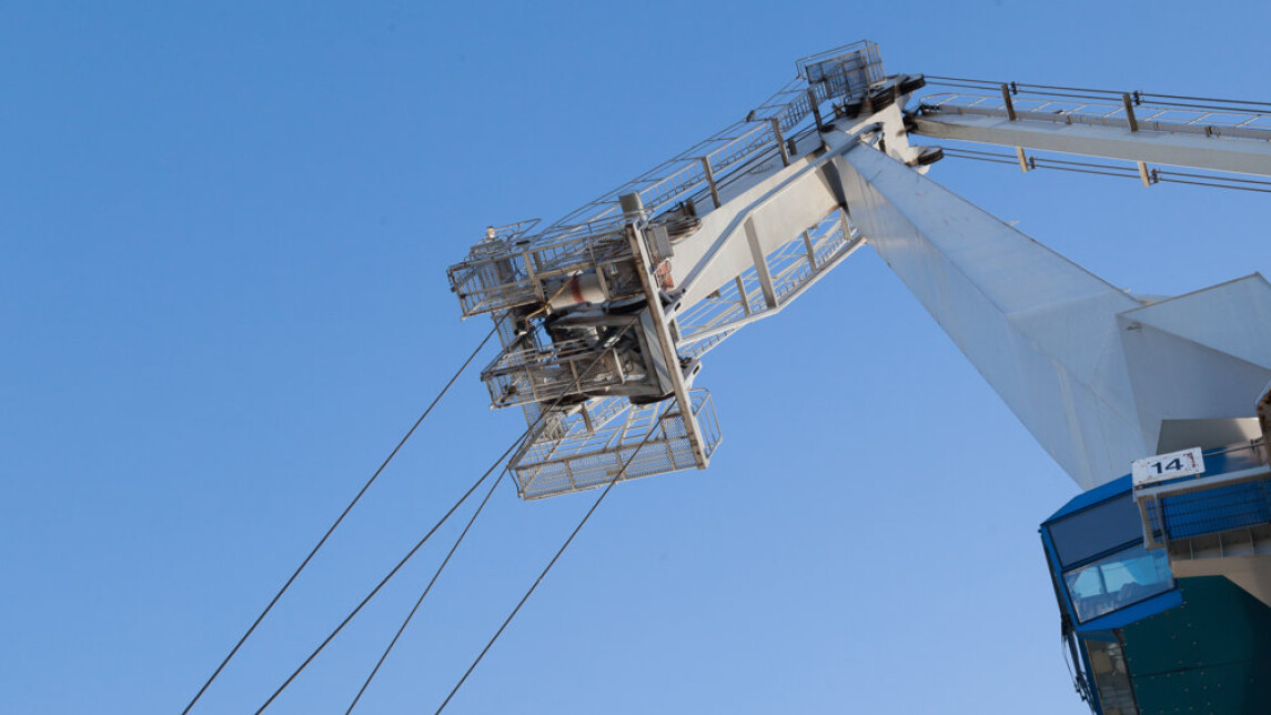 Satamanosturi sinistä taivasta vasten