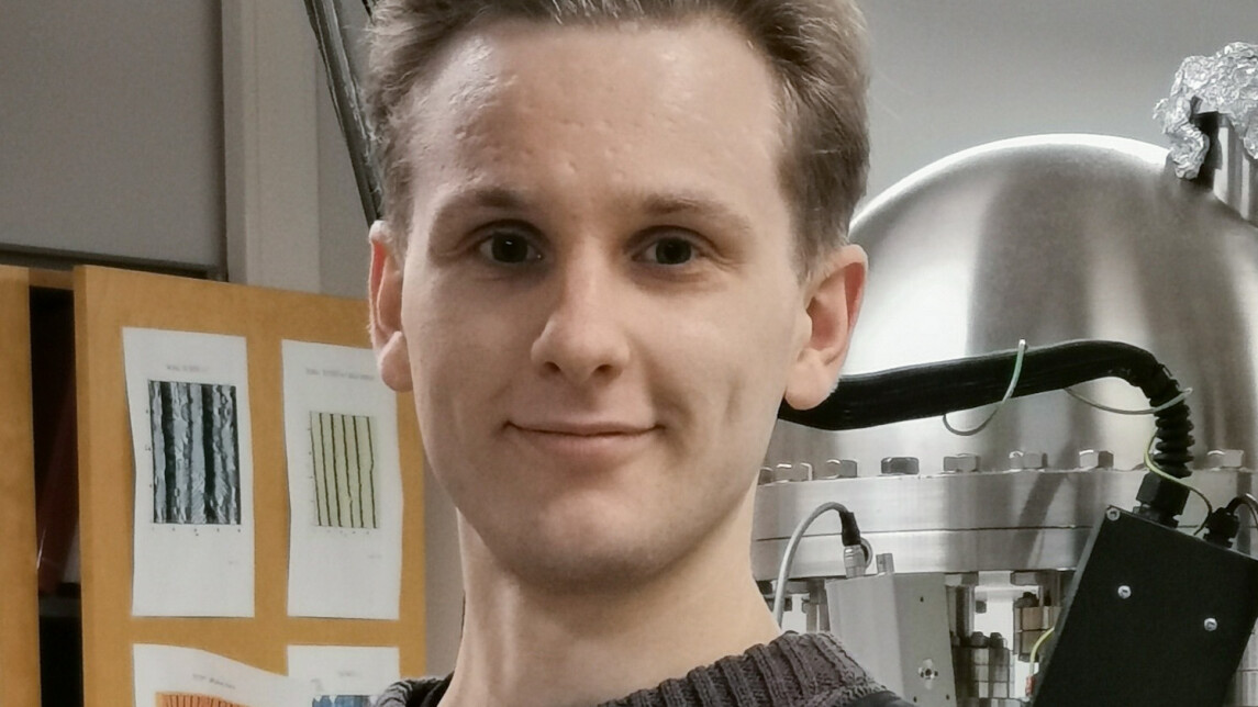 Väittelijän potrettikuva, taustalla näkyy laboratoriolaitteistoa