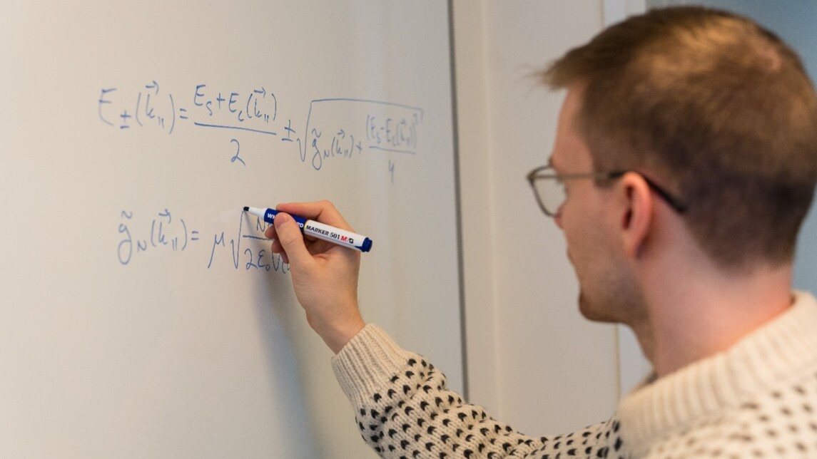 Henkilö tekee laskutoimituksia valkotaululle