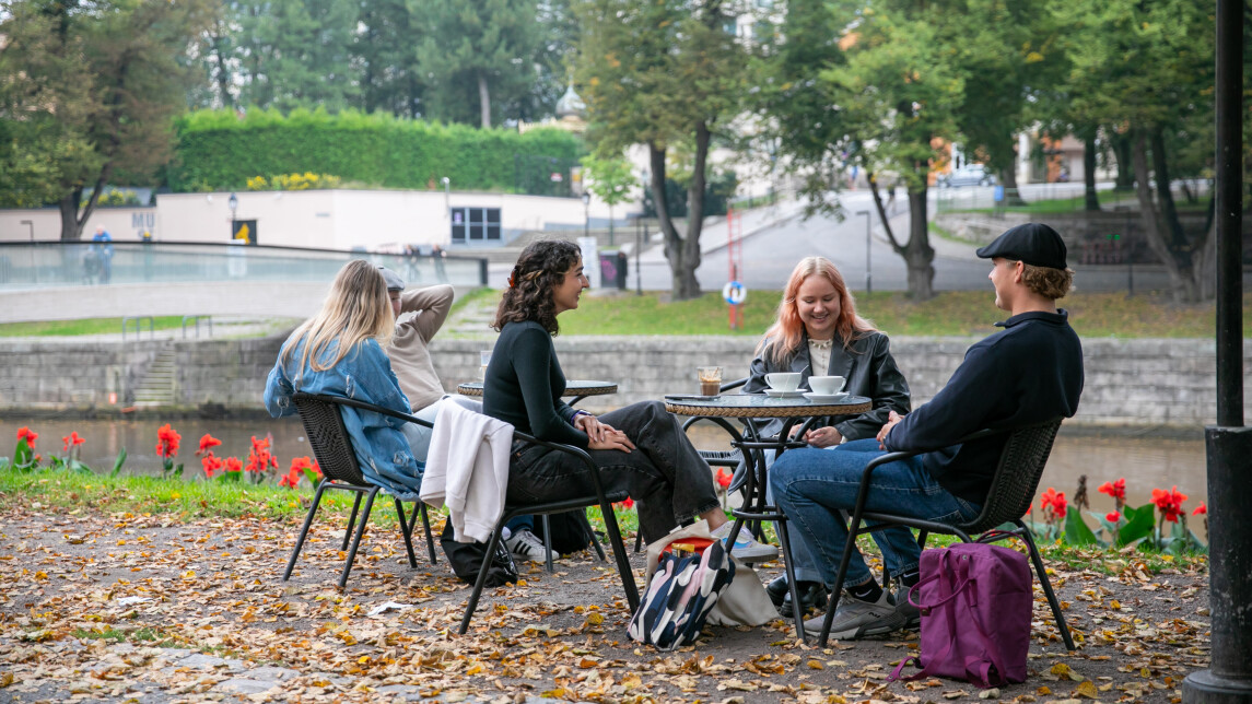 Four studends sitting outside having coffee