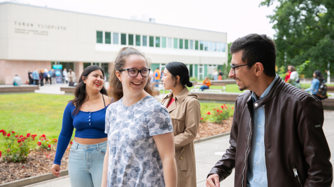 Four students walking together looking at each other