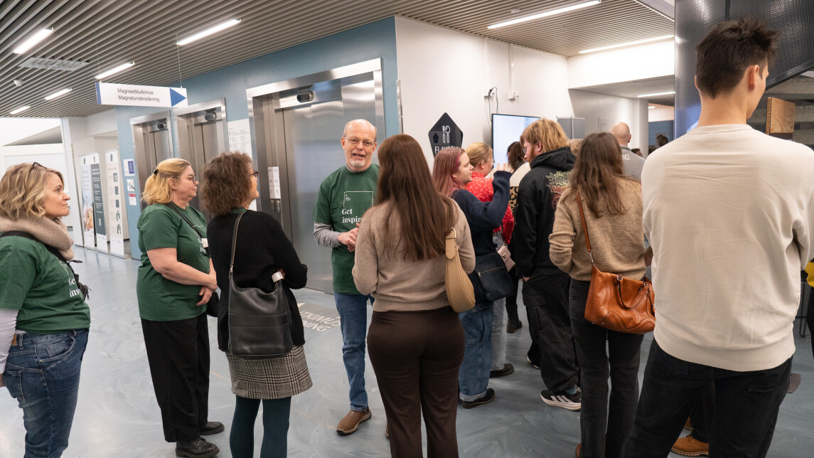 Ihmisiä Medisiinan aulassa keskustelemassa. Pekka Hänninen puhuu vanhemmille.