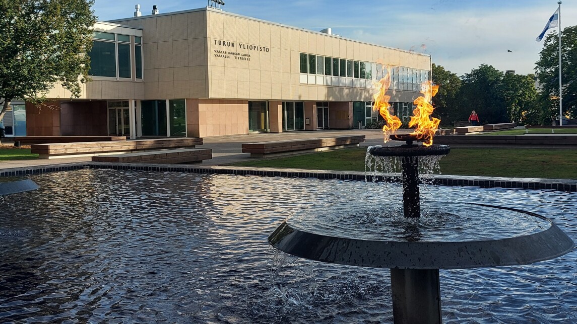 Yliopistonmäen aukio, jossa suihkulähteessä palavat soihdut ja päärakennus taustalla.
