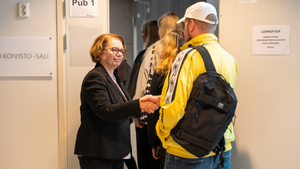 Rehtori Marjo Kaartinen kättelee uutta opiskelijaa