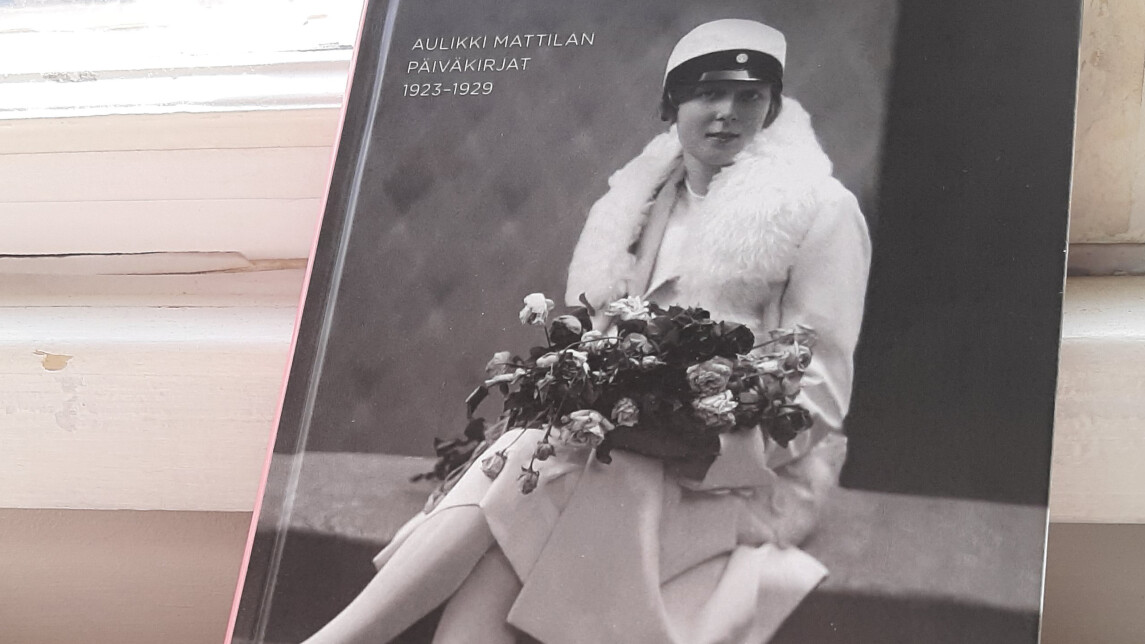 Kirja nojaa ikkunalautaan.