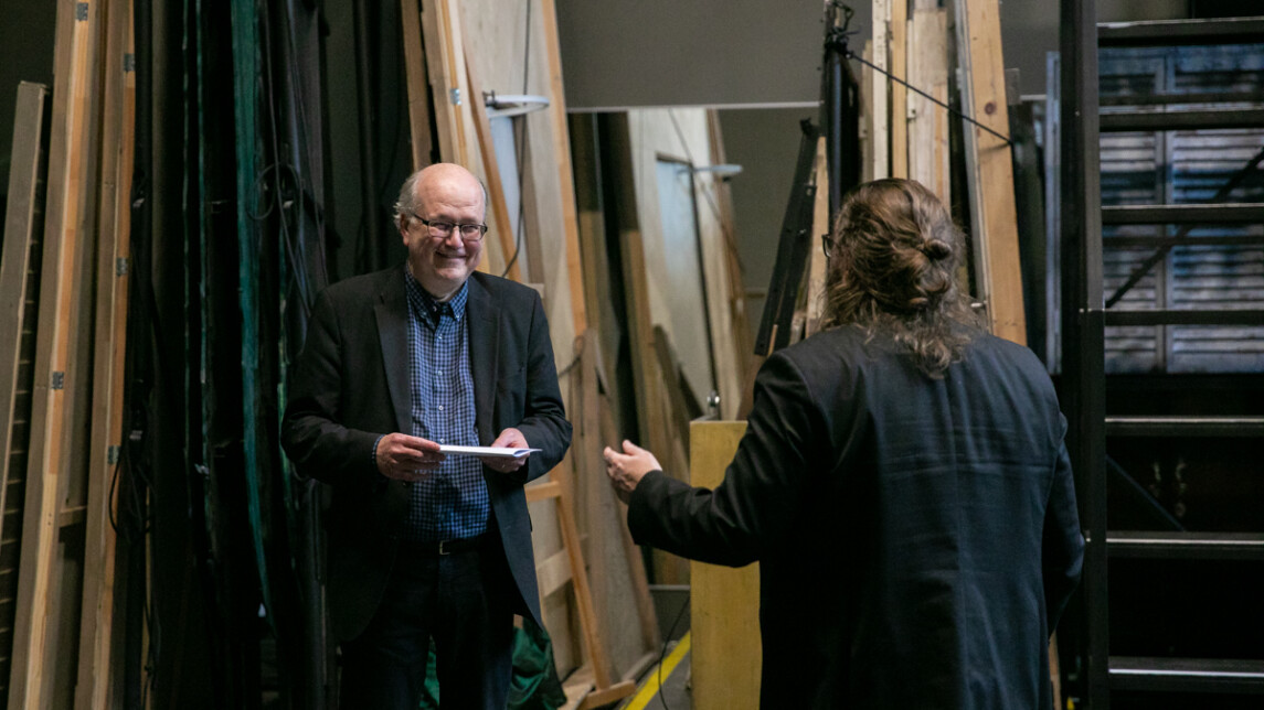 Kaksi henkilöä miettimässä Akateemisen vartin esitystä.