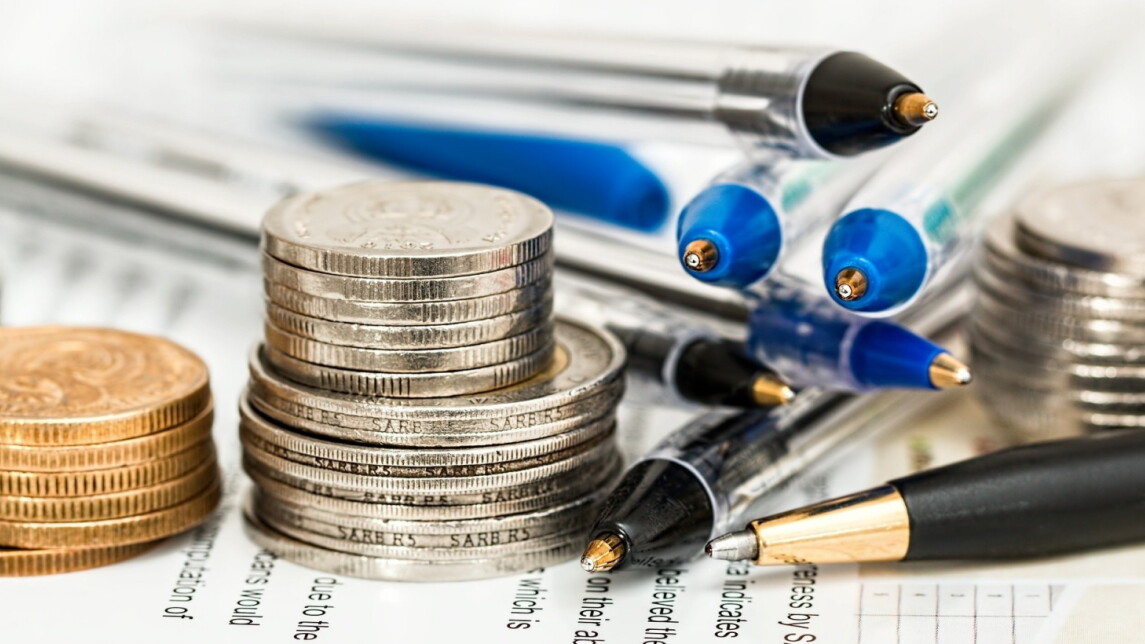 Kuvassa kolikoita, kyniä ja papereita.