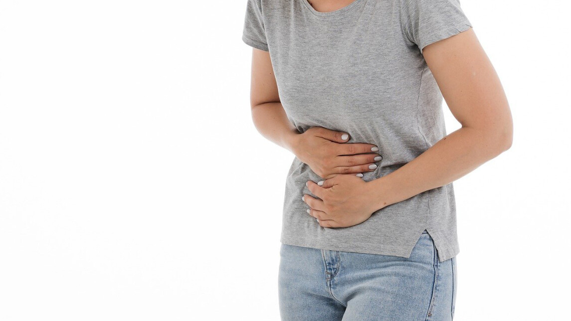 Kuvituskuva, jossa henkilö pitelee kipeää vatsaansa.