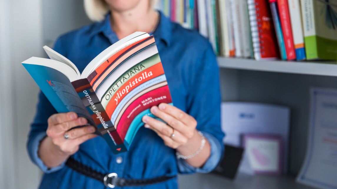 Tutkija lukee kirjaa Opettajana yliopistolla.