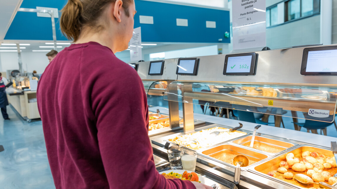 Asiakas itsepalveluravintolan linjastolla valitsemassa ruokaa