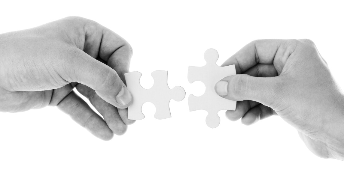 two hands joining a puzzle piece