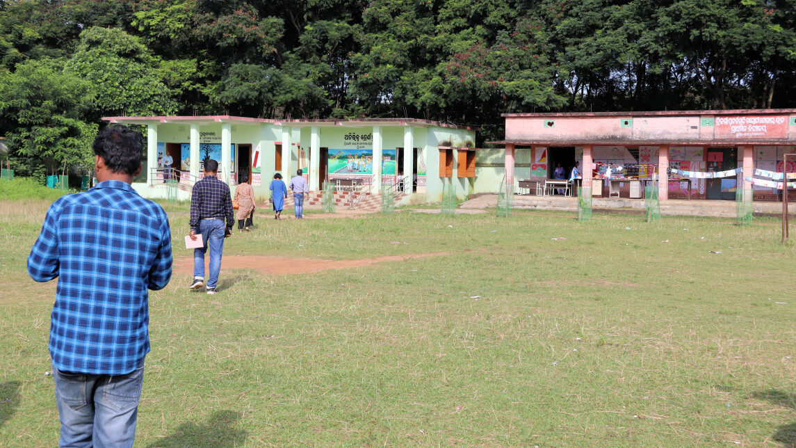People walking towards a school building in rural India