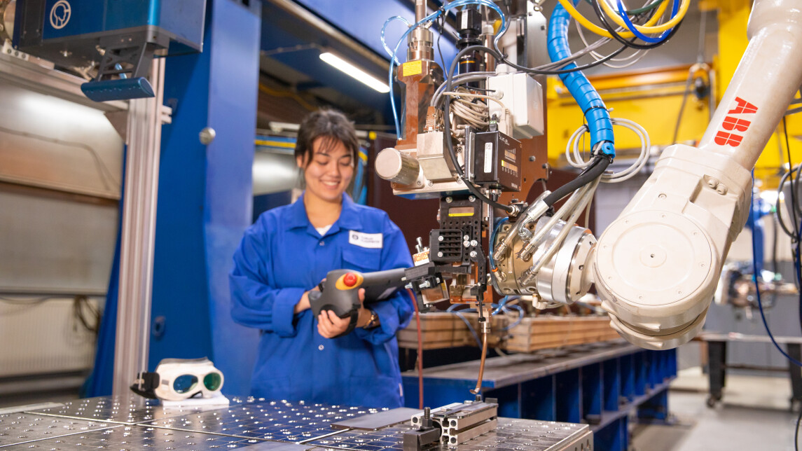 Henkilö työskentelemässä laserhitsauslaitteen kanssa.