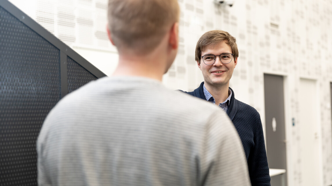 Kaksi henkilöä keskustelee käytävällä.