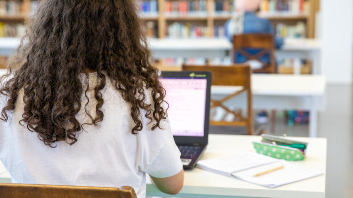 Opiskelija opiskelemassa kirjastossa