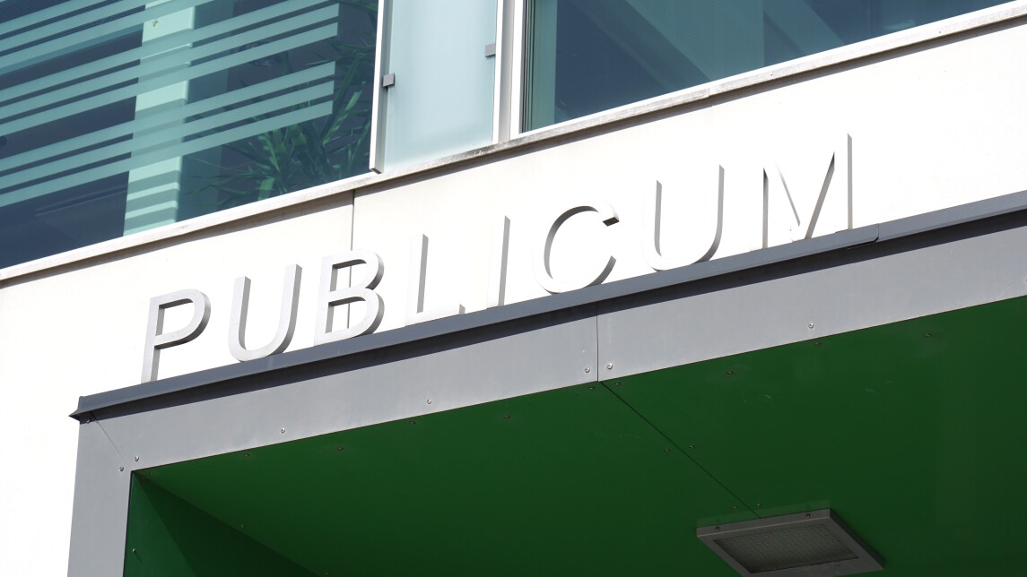 Publicum-rakennuksen nimikyltti pääoven yläpuolella.