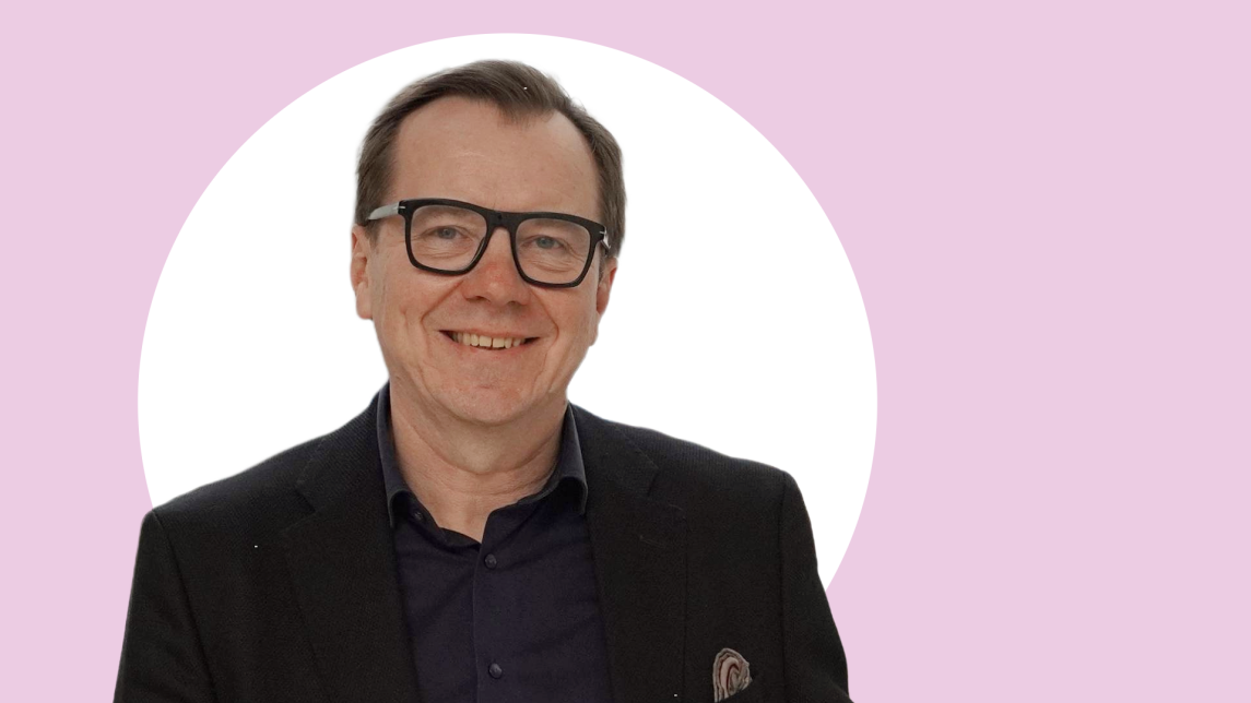 Jukka Westermarck lähikuvassa, taustalla vaaleanpunaista ja valkoista.