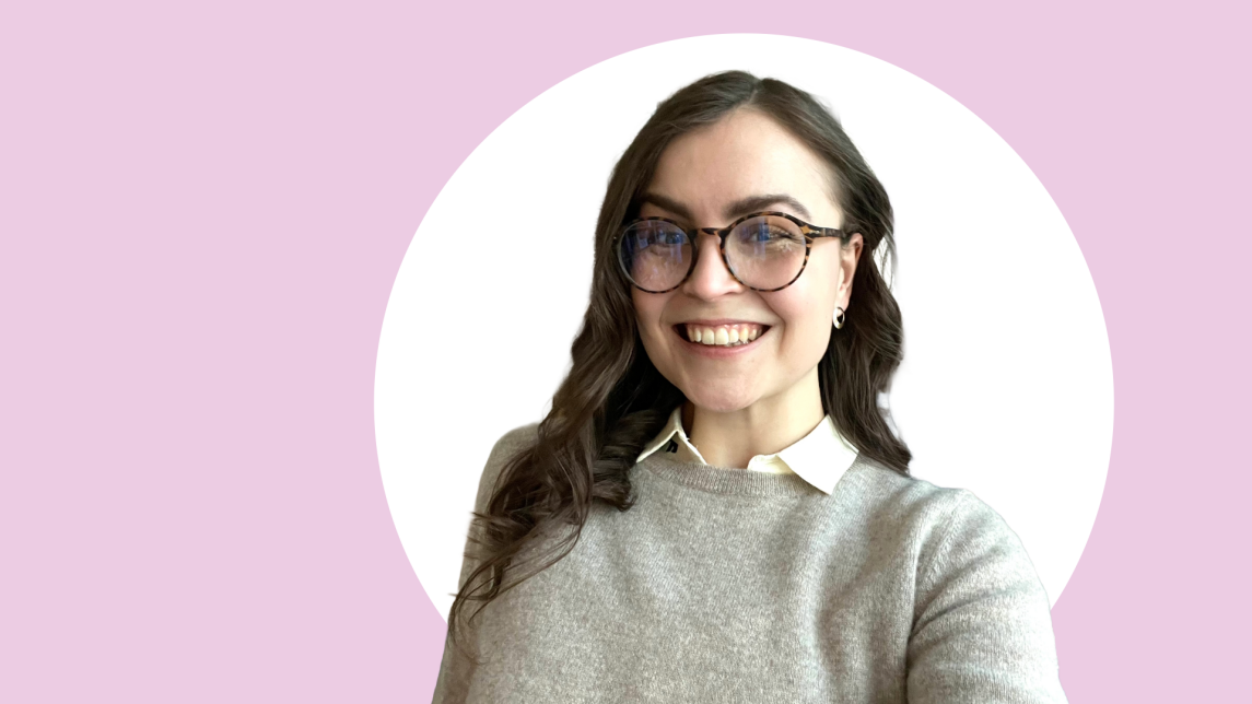 Reetta Kyynäräinen lähikuvassa, taustalla vaaleanpunaista ja valkoista.