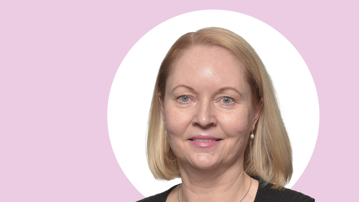 Tanja Vähämäki lähikuvassa, taustalla vaaleanpunaista ja valkoista.
