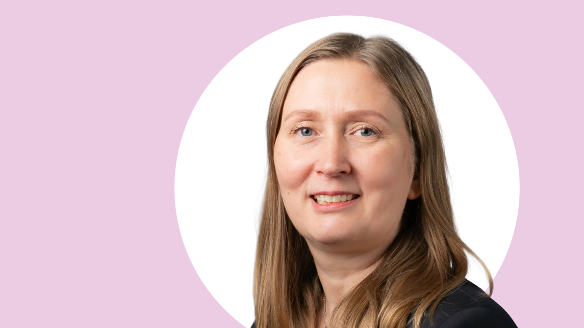 Anne Quarshie lähikuvassa, taustalla vaaleanpunaista ja valkoista.