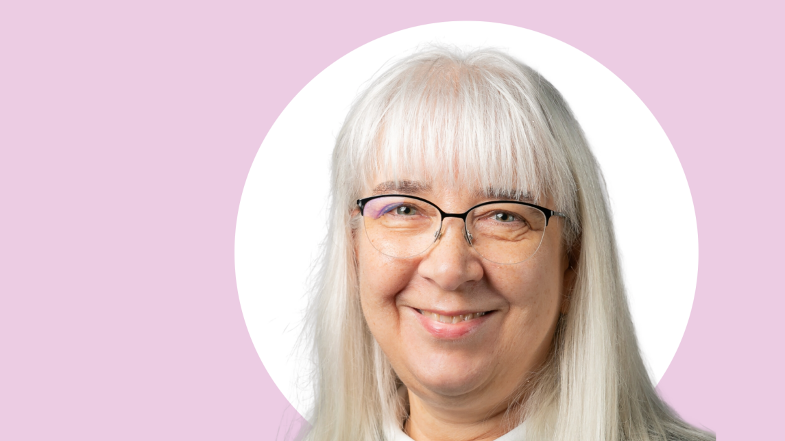 Katriina Siivonen lähikuvassa, taustalla valkoista ja vaaleanpunaista.