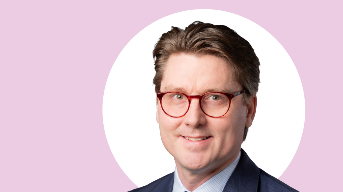 Tuomas Kiviniemi lähikuvassa, taustalla vaaleanpunaista ja valkoista.
