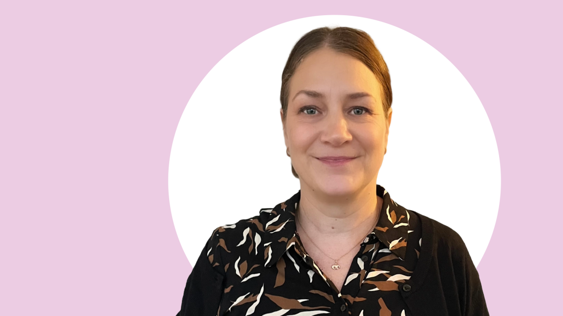 Tiina Kurvinen lähikuvassa, taustalla vaaleanpunaista ja valkoista.