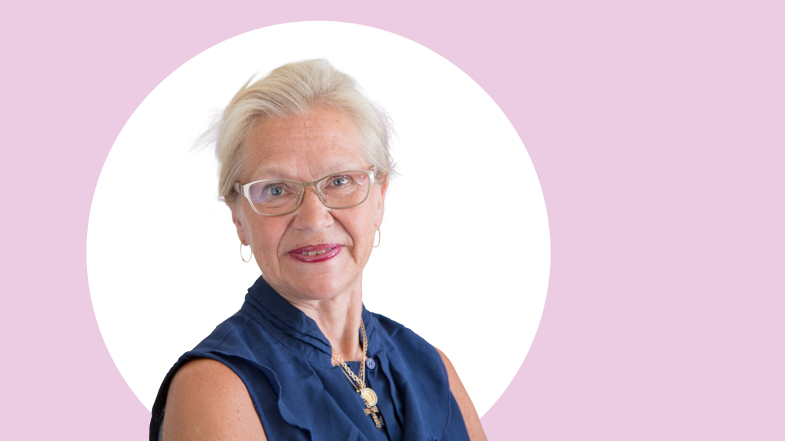Sirkka Heinonen lähikuvassa, taustalla vaaleanpunaista ja valkoista.