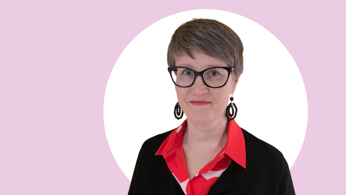 Outi Veivo lähikuvassa, tausta vaaleanpunainen ja valkoinen.