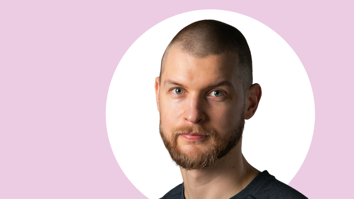 Veli Virmajoki lähikuvassa, taustalla vaaleanpunaista ja valkoista.