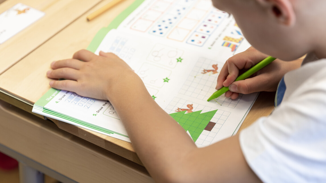 Lapsi pulpetin ääressä.