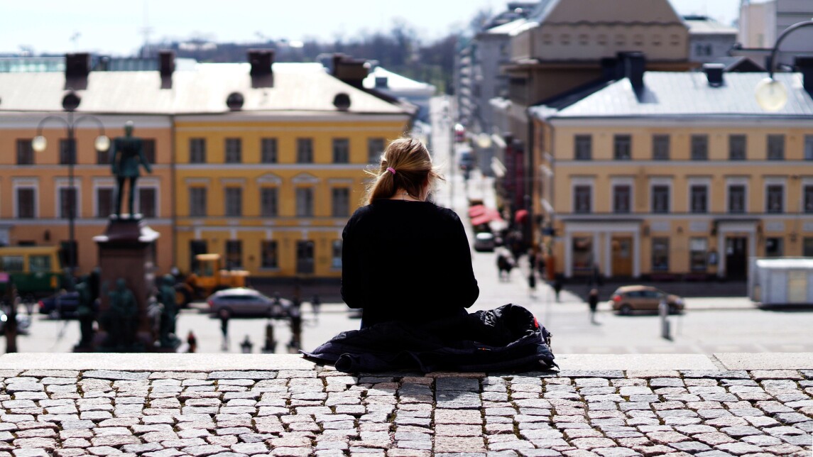 Nuori ihminen istuu Helsingin Suurkirkon portaiden yläpäässä yksin.