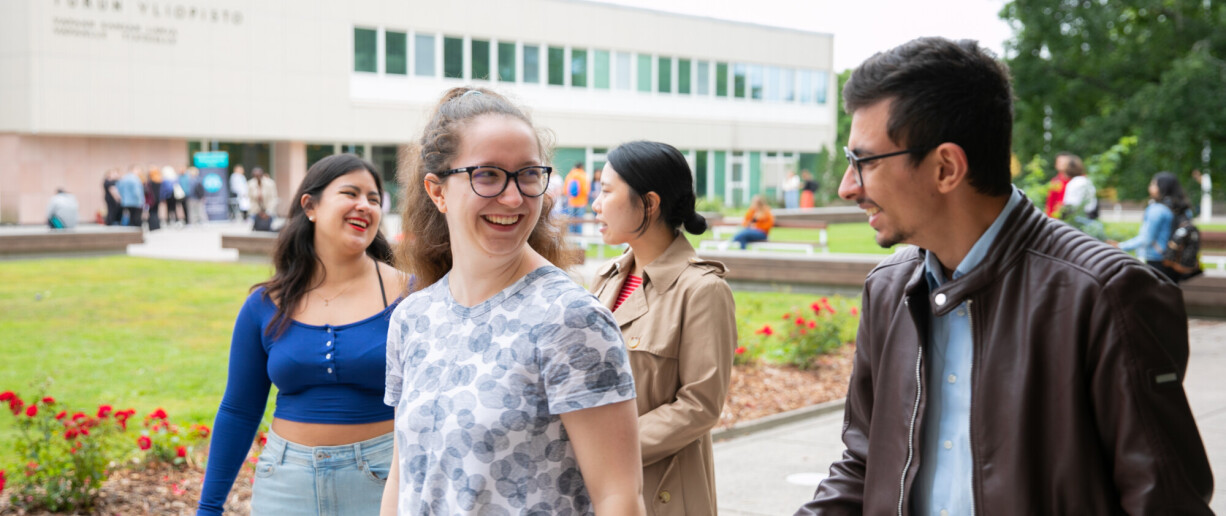 Four students walking together looking at each other
