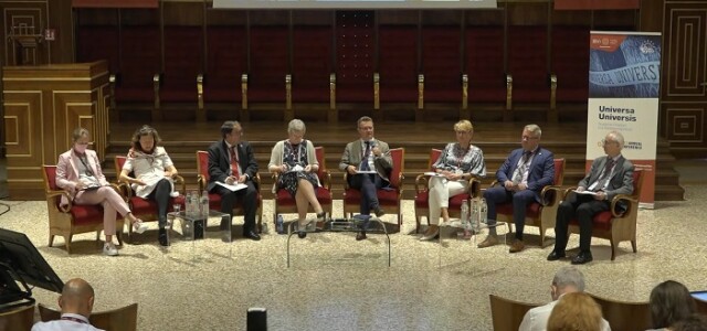 Seven people sitting next to one another, participating a panel discussion