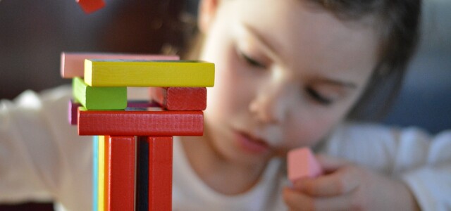 Lapsi rakentamassa puupalikoista tornia.