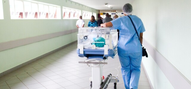 Sairaanhoitaja kuljettaa potilasta sairaalassa.