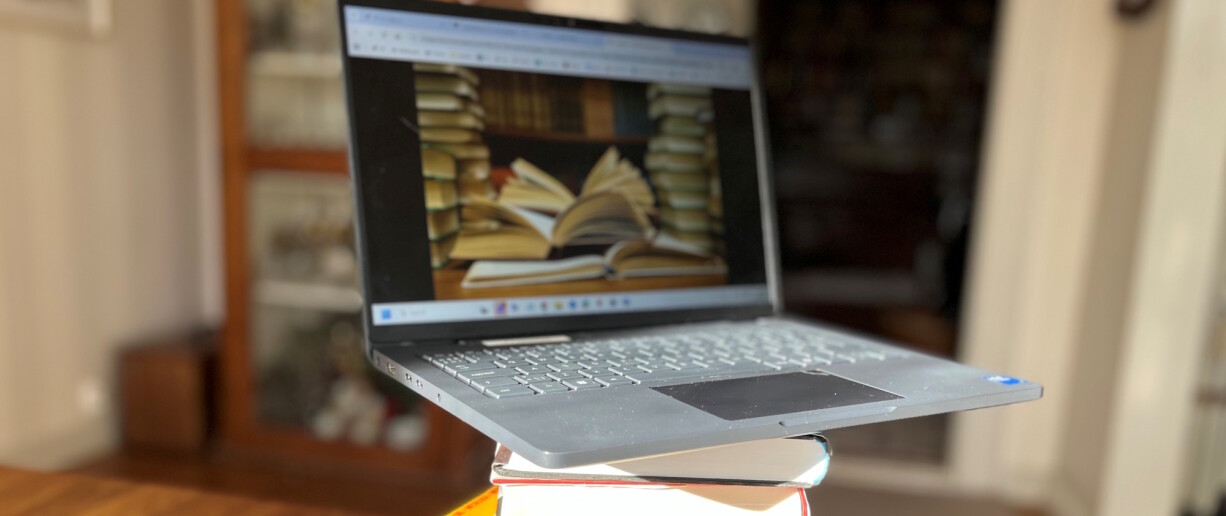 Läppäri kirjojen päällä