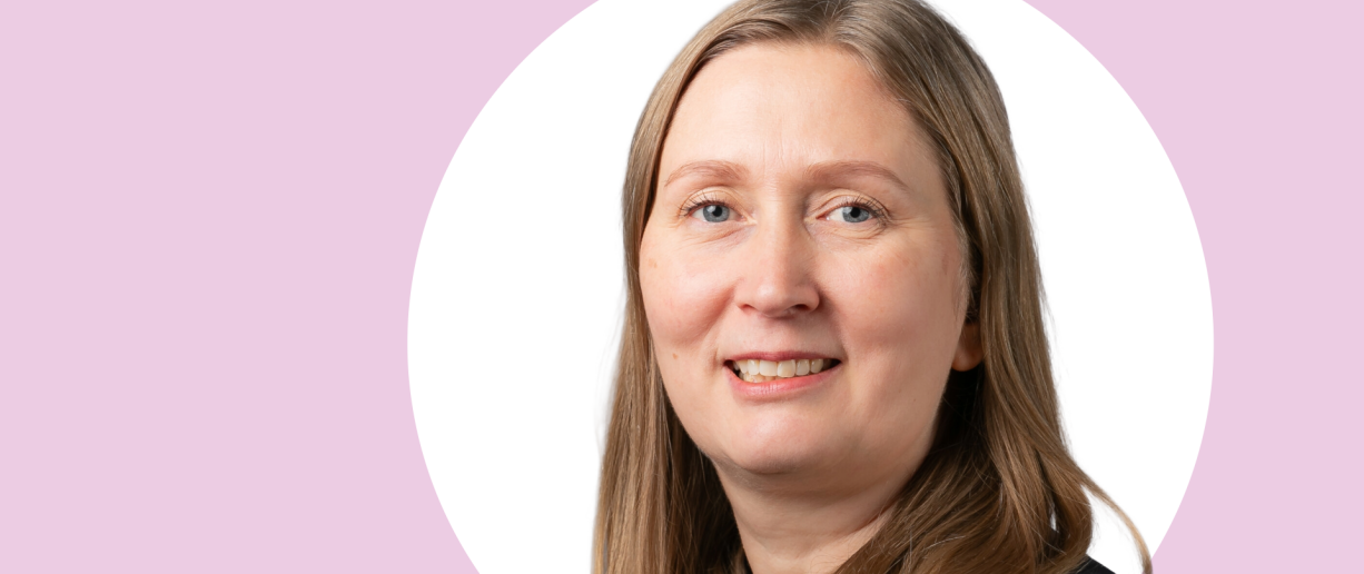 Anne Quarshie lähikuvassa, taustalla vaaleanpunaista ja valkoista.