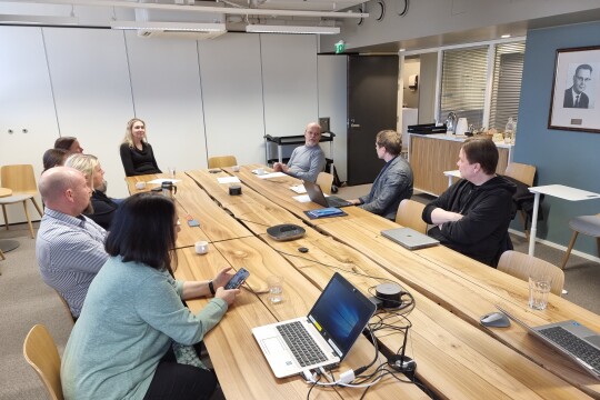 Ihmisiä pöydän ääressä keskustelemassa