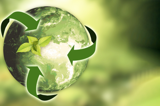 vihreä maapallo jonka ympärillä kierrätysnuolet