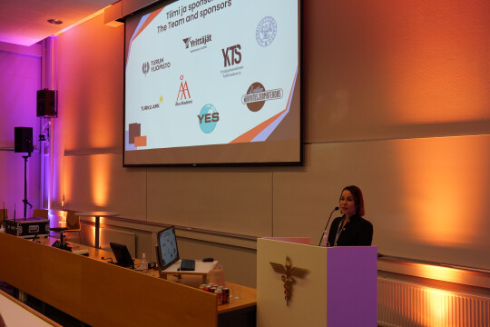 Sanna Ilonen puhuu konferenssiyleisölle.