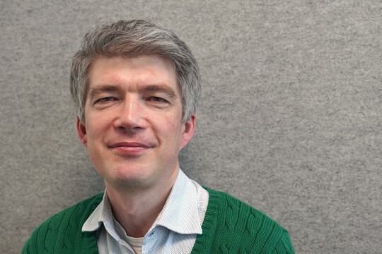 David Molnar closeup in front of a gray wall