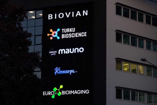 Pimeällä otettu kuva BioCityn seinän logoista, joissa myös Euro-BioImaging