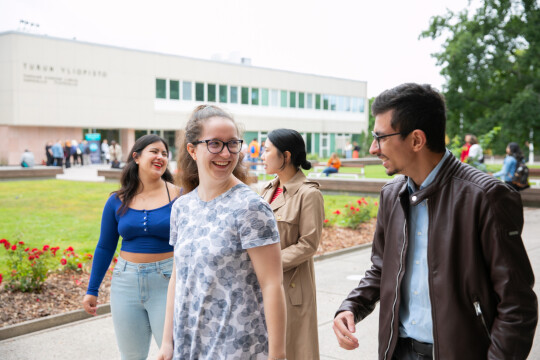 Four students walking together looking at each other