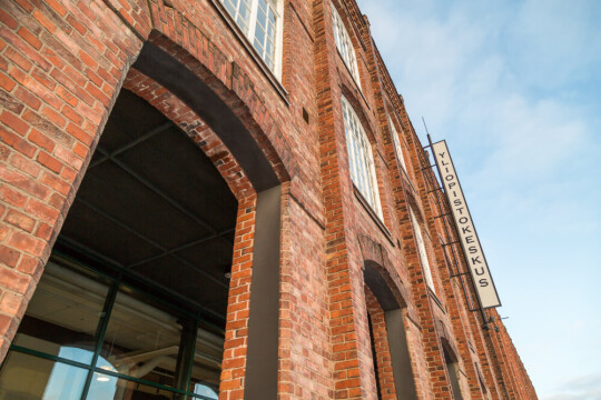 Porin yliopistokeskuksen seinää, taivasta ja nimikyltti